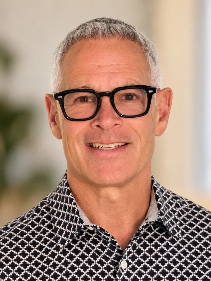David Lewis smiling in a casual patterned shirt
